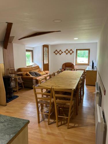 - un salon avec une grande table et des chaises en bois dans l'établissement Gites De La Racine, à Girmont-Val-d'Ajol