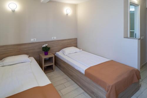 a bedroom with two beds and a window at City Hotel Bucharest in Bucharest
