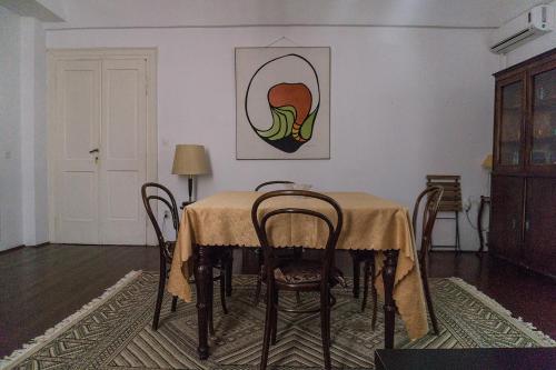 a dining room with a table with chairs and a painting at Giunio house, Old town centre in Korčula