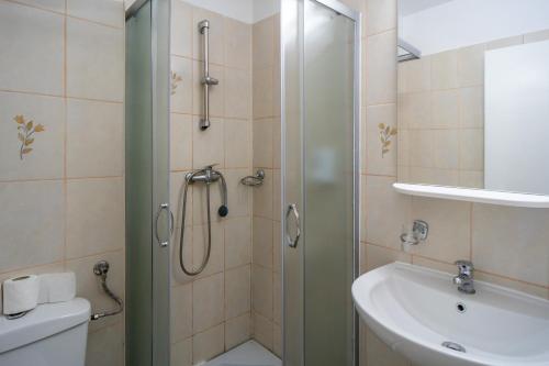 a bathroom with a shower and a sink at City Hotel Bucharest in Bucharest