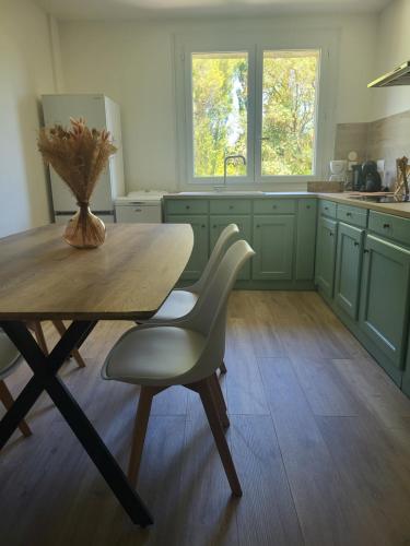 a kitchen with a wooden table with a vase on it at Domaine d'Ella Jourre in Canet d'Aude
