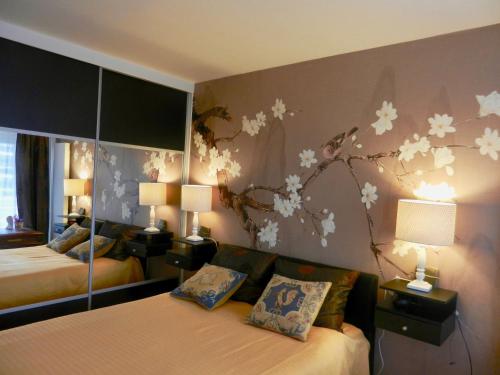 une chambre avec deux lits et des fleurs peintes sur le mur dans l'établissement Deux pièces de standing, climatisé, à Paris