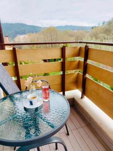 a glass table with a cup of coffee on a balcony at Villa Pino in Velingrad
