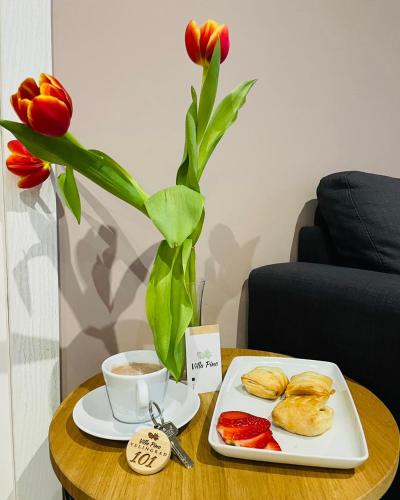 a table with a plate of food and a vase with flowers at Villa Pino in Velingrad