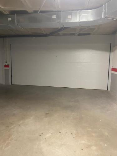 a garage with a white wall and a concrete floor at Lujo en el centro con parking privado 1 in Adra