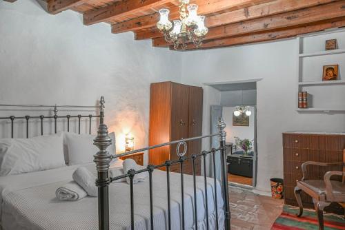 a bedroom with a bed and a chandelier at Anoi Traditional House Patmos Architectural Charm in Patmos
