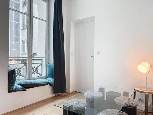 - un salon avec une table en verre et une fenêtre dans l'établissement Appartement contemporain au cœur de Paris, à Paris