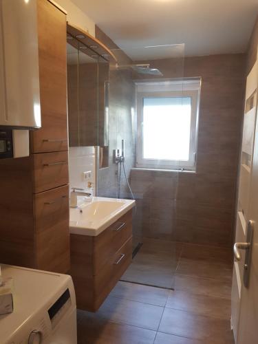 a bathroom with a tub and a sink and a window at Sonnige 3 Zimmer Ferienwohnung Sun Mountain in Rechberghausen