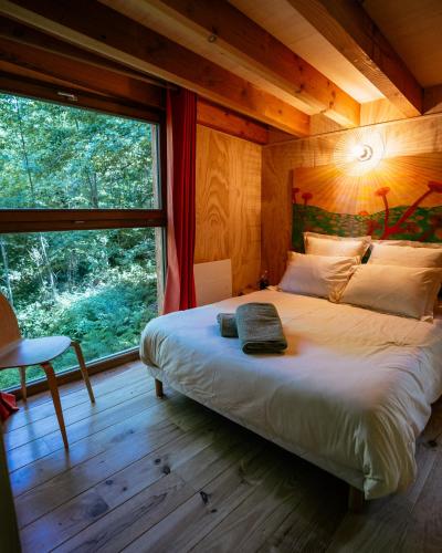 une chambre avec un lit et une grande fenêtre dans l'établissement Domaine de Ribeaugoutte, à Saint-Nabord