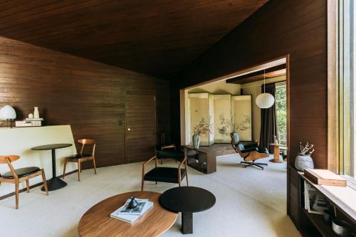 箱根町にあるAKNOT hakone 大涌谷を望むモダニズム建築 東京から90分の木製の壁のリビングルーム(テーブル、椅子付)