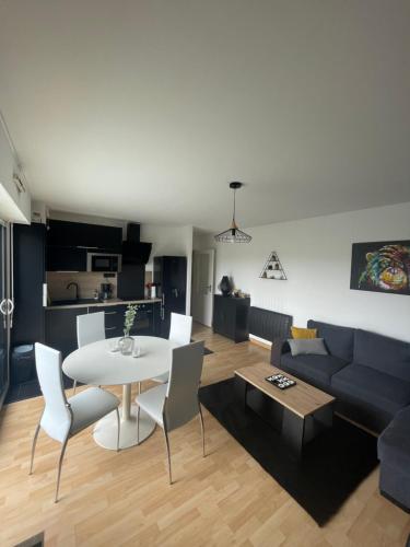 - un salon avec une table blanche et un canapé bleu dans l'établissement Appartement Cosy + Balcon, à Vannes