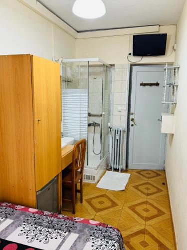 a small room with a desk and a shower at Hostal Fuentesol in Madrid