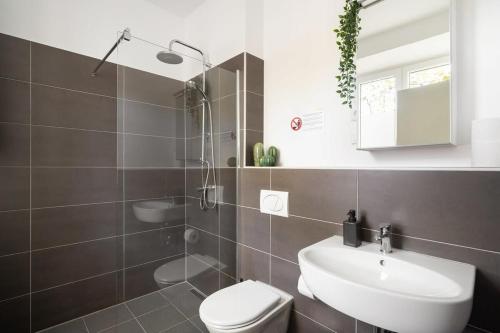 ミュンヘンにあるApartment an der Theresienwieseの白いトイレと洗面台のあるバスルーム