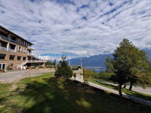 a view of a building with a tree in the grass at PROVINCIALE 79 in Magreglio