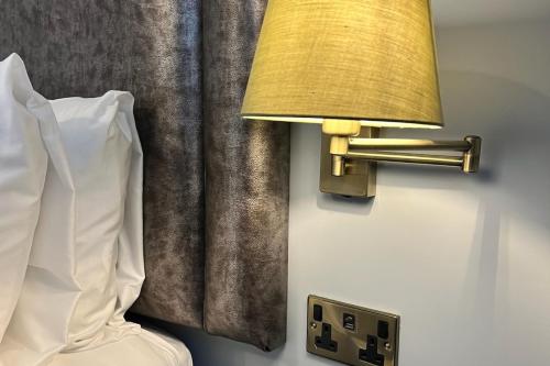a lamp on a wall next to a bed at The Elizabeth House Hotel in Southampton