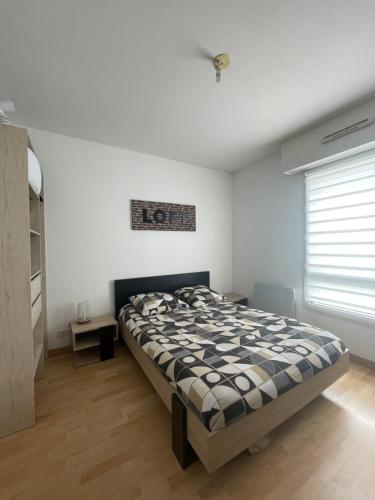 une chambre avec un lit dans une pièce dans l'établissement Appartement Cosy + Balcon, à Vannes
