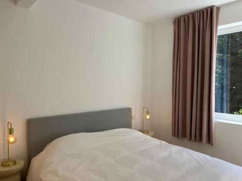 a bedroom with a white bed and a window at House of Legend in Antwerp