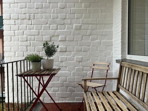 a bench and a table with two plants on a balcony at House of Legend in Antwerp