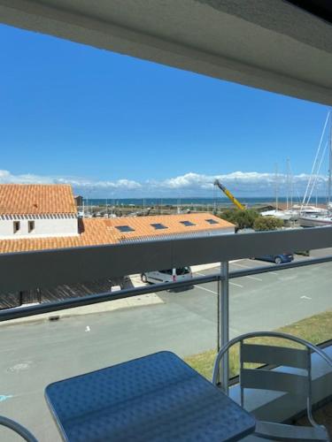 a balcony with a blue bench and a view of a building at Hotel Bord A Bord in Noirmoutier-en-l'lle