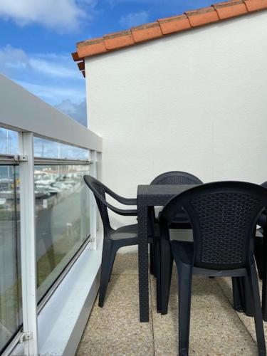 two chairs and a table on a balcony at Hotel Bord A Bord in Noirmoutier-en-l'lle