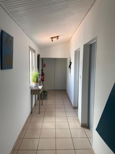 a hallway of an office with a table and a hallwayngthngthngthngthngth at Hotel Bord A Bord in Noirmoutier-en-l'lle