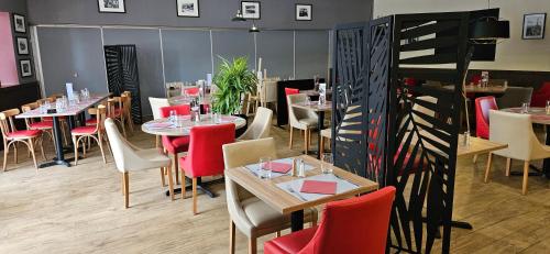 a dining room with tables and chairs and red chairs at Hotel Le Circuit Le Mans in Le Mans