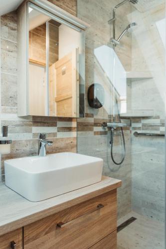 a bathroom with a white sink and a shower at Bogi Kuckó, Farkasgyepű in Farkasgyepů