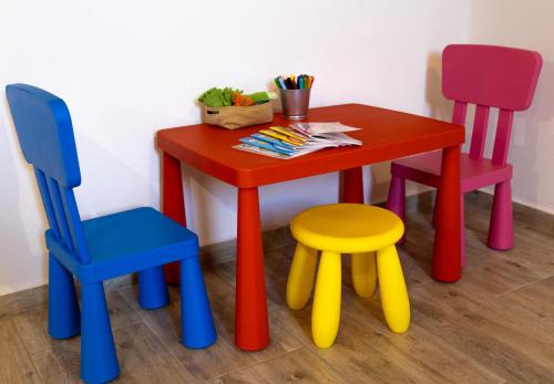 a table with three chairs and a table with aicolored table at Bogi Kuckó, Farkasgyepű in Farkasgyepů