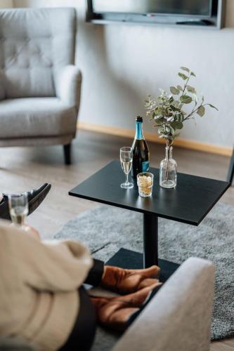 a black table with two glasses and a bottle of wine at Bohusgården Hotell & Konferens in Uddevalla