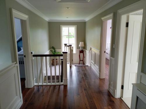 a hallway of a home with wooden floors and doors at Conveniently located house to enjoy all of Kerry in Tralee