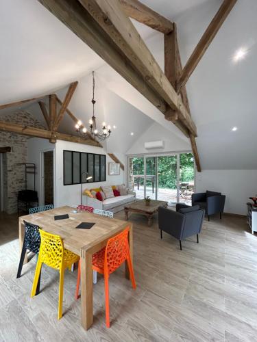 un salon avec une table et des chaises en bois dans l'établissement Gîte de la forêt de Longuenée, à Saint-Clément-de-la-Place