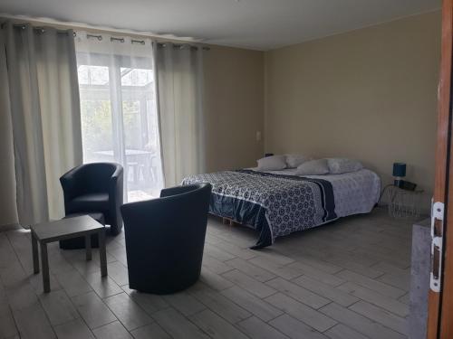une chambre avec un lit, une chaise et une fenêtre dans l'établissement Chambre d'hôtes Jonquières, à Jonquières