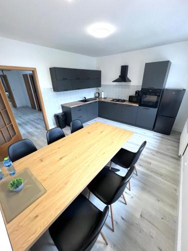 a kitchen and dining room with a wooden table and chairs at GrandLux Villa & Spa in Teplice