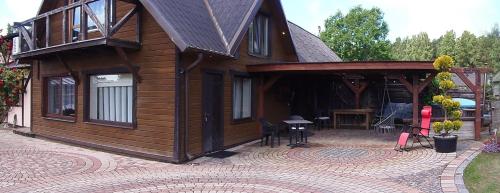a large wooden cabin with a patio and a table at Dīva in Pāvilosta