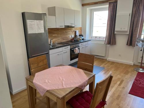 a kitchen with a table and a dining room at Garten Apartment in Nodendorf