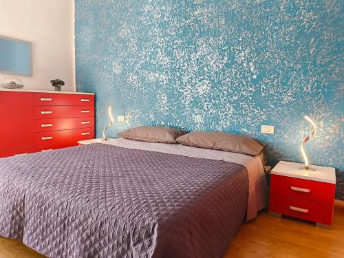 une chambre avec un lit et un mur bleu dans l'établissement Casa vacanze Ovidio, à Sulmona