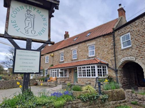 an old brick building with a sign in front of it at The Countryman’s Inn in Hunton