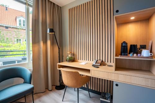 a room with a desk and a chair and a window at Hotel Kontakt der Kontinenten in Soesterberg