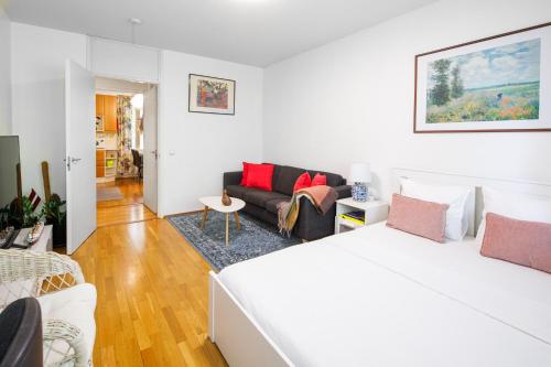 a white bedroom with a bed and a couch at Helsinki Green Retreat in Helsinki