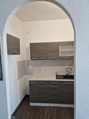 a kitchen with brown cabinets and a sink at Pension Antalya in Friedrichshafen