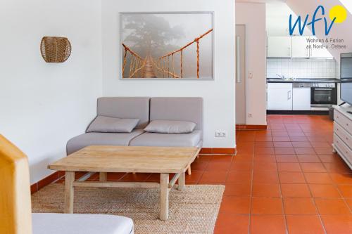 a living room with a couch and a table at Ferienhaus am Gutspark Drankse Ferienwohnung Seegras in Dranske