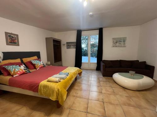 une chambre avec un lit et un canapé dans l'établissement Villeneuve loubet studio Cigalou, à Villeneuve-Loubet