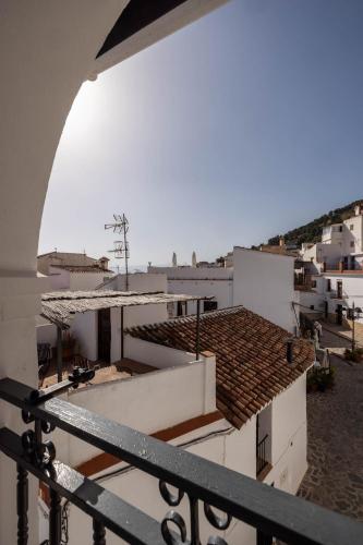 a view of the roofs of buildings from a balcony at Olive & Ivy Guesthouse in Canillas de Aceituno