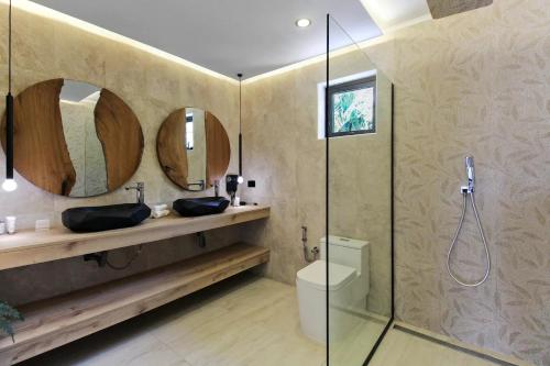 une salle de bain avec deux lavabos et une douche avec miroirs dans l'établissement Bocobay Zen Garden Villa, à Noord