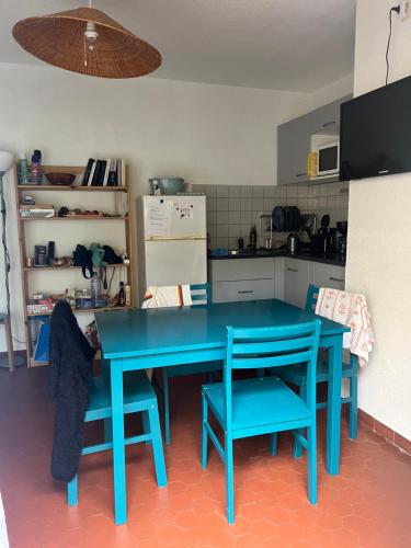une table bleue et deux chaises dans une cuisine dans l'établissement Maison, au Barcarès