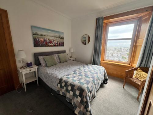 a bedroom with a bed and a large window at Morven Guest House Carnoustie in Carnoustie
