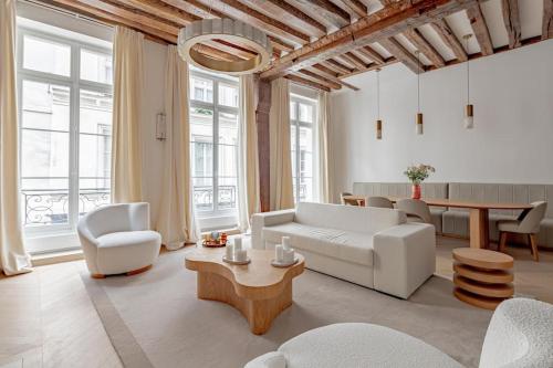 un salon avec un canapé blanc et une table dans l'établissement Stylish Rue des Rosiers Gem Brand New 2-Bedr, à Paris