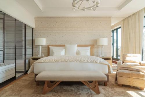 a bedroom with a large bed and a chandelier at Cheval Blanc Paris & Dior Spa Cheval Blanc Paris in Paris