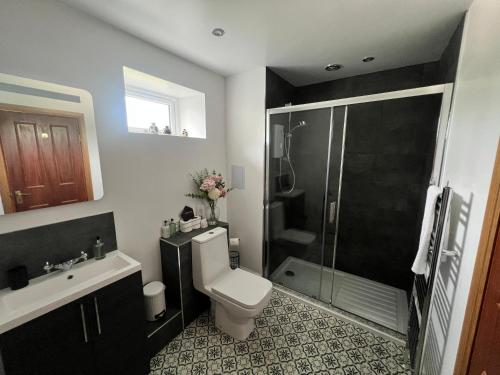 a bathroom with a shower and a toilet and a sink at Morven Guest House Carnoustie in Carnoustie