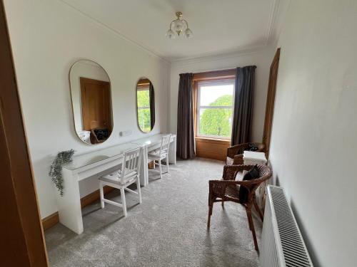 a room with a table and chairs and a mirror at Morven Guest House Carnoustie in Carnoustie